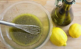 В смесь масла и сока лимона всыпать травы: орегано, базилик и розмарин, размешать заправку.