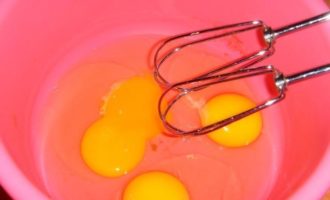 Яйца разбейте в чашу миксера или удобную мисочку, а затем хорошенько взбейте их до образования пены, постепенно добавляя в яйца весь сахар.
