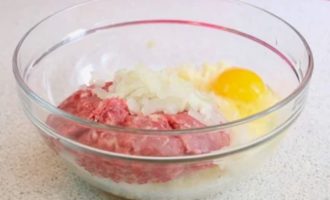 Мясной фарш положить в глубокую миску, добавить к нему отжатую ошпаренную капусту, соль, перец,  яйцо и хорошо перемешать.