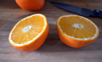 Апельсин тоже нужно как следует вымыть, а затем разрезать на 4 части. Удалите косточки, если таковые имеются. Обратите внимание, что счищать кожуру с апельсинов не нужно.