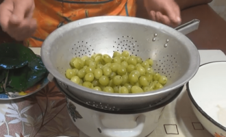 После листья вишни убрать в отдельную посуду, поместить ягоды в дуршлаг и дать стечь воде.