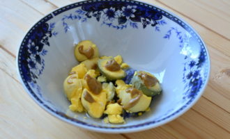 В отдельную емкость положите яичные желтки, добавьте к ним уксус, растительное масло и горчицу. После этого разотрите ингредиенты при помощи вилки или ложки до однородной массы.