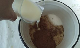 В удобной миске соедините какао, молоко и сахарный песок. Обязательно оставьте пару ложек молока, которое будете соединять с мукой на другом этапе приготовления. Миску поместите на медленный огонь, чтобы все ингредиенты равномерно нагревались и смешивались.