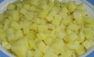 Картофелины почистите от кожуры, помойте и нашинкуйте на маленькие кубики. Сварите картофель до готовности в 1,5 л подсоленной воды, не забывая снимать пенку с поверхности.