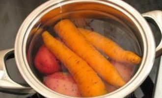 Затем в кипяченной воде варим почищенные картофель и морковь.