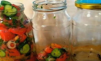 В чистые литровые банки насыпать по 5 горошин душистого перца. Затем в них компактно уложить нарезку овощей.