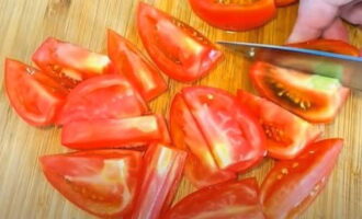 Небольшими дольками нарезать помидоры.
