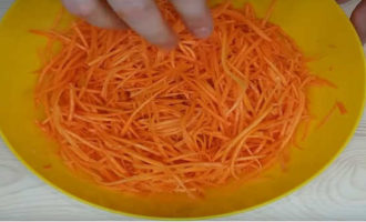На специальной терке или с помощью комбайна с насадкой для корейской моркови измельчить вымытую морковь. Всыпать в нее пару щепоток соли и размять рукой или вилкой с целью размягчения овоща.
