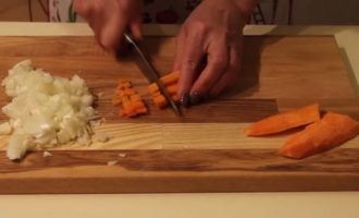 Очищаем овощи. Лук, а также морковку нарежем тонкими полосками. Дольки чеснока режем на небольшие пластинки. Картофелины будем нарезать на небольшие квадратики, кладем их в тарелку с водой. Капусту промыть и покрошить кочан до кочерыжки.