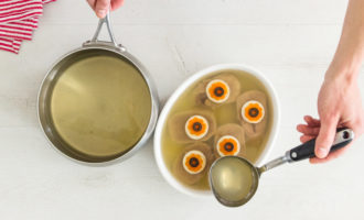 Берём посуду с бортиком, выливаем желе на дно и отправляем в холодильник на 5 минут. Маслины, морковь и яйца режем колечками. На краях морковных кружочков вырезаем зубчики. Достанем форму из холодильника, положим куски языка. На каждый сверху - кружок яйца, на него фигуру моркови и в центре маслину. Заливаем сверху желе и ставим в холод для дальнейшего застывания на 2 часа или на всю ночь.