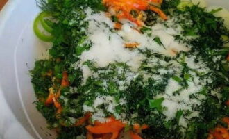 В глубокую посуду переложить нарезку всех овощей с зеленью и высыпать к ним соль с сахаром.