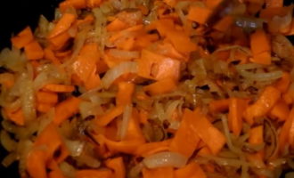На сковороде разогреваем растительное масло, выкладываем лук, морковь и жарим примерно 5 минут, после этого добавляем к массе томаты в собственном соку, мешаем и тушим 5 мин.