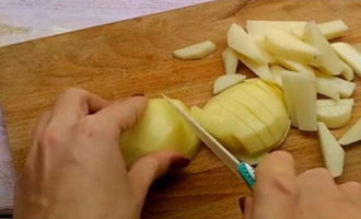 Нарежьте картофелины на брусочки примерно одинакового размера, чтобы они равномерно запеклись. Форма нарезки картофеля может быть любой.