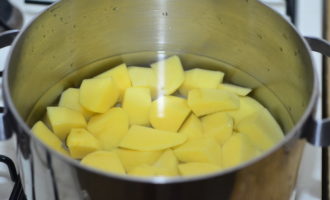 В кастрюлю для варки супа налейте 3 литра воды, положите в нее нарезанный картофель и на небольшом огне и под закрытой крышкой сварите его до полуготовности.