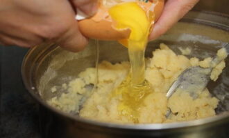 Пока смесь ещё тёплая - добавьте яйцо и начните вымешивать руками, если удобно, переложите на стол, присыпанный мукой. 