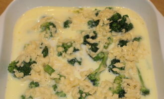 Заливаем брокколи в форме приготовленной яично-молочной смесью с сыром. При необходимости разравниваем осевший сыр на поверхности капусты.