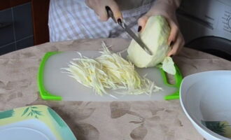 Удалите с белокочанной капусты верхние листья, затем промойте ее. Нашинкуйте капусту тонкой соломкой. Если в арсенале есть специальная терка, воспользуйтесь ей.