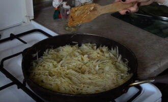 Обжаренные овощи переложите в другую емкость, а сковороду наполните нашинкованной капустой. Тушите ее в течение 10-15 минут до мягкости.