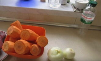 Репчатый лук очистите от шелухи, промойте под холодной проточной водой. Морковь тщательно вымойте, а затем очистите от кожуры с помощью овощечистки.