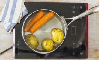 Чтобы приготовить классический салат Оливье с колбасой отвариваем овощи – морковку и картошку.