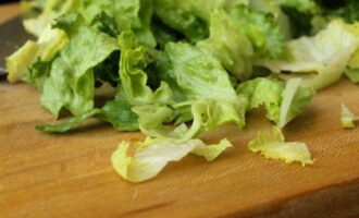 Разделите  листья салата, вымойте каждый очень тщательно, отрежьте нижнюю прикорневую часть, нарвите их руками на произвольные куски.