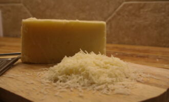 Сыр измельчите на мелкой тёрке и переложите в отдельное чистое и сухое блюдо.