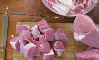 Как приготовить шурпу из говядины по классическому рецепту? Мясо нарезаем крупными квадратными кусочками. Погружаем говядину в казан. Добавляем соль, воду и специи.