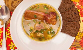 Разливаем горячий гороховый суп с копчеными ребрышками по тарелкам. Подаем блюдо к столу вместе с хлебом или сухариками. Приятного аппетита!