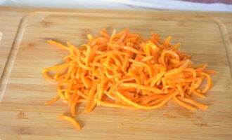 Соломку корейской морковки разрежьте на несколько частей.