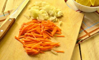 Тонкой соломкой режем морковь, лук измельчаем. Обжариваем овощи 3 минуты в растительном масле, затем кладем их в суп.