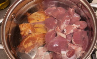 Мясные продукты кладем в кастрюлю и заливаем их водой. Ставим на плиту, варим 30 минут после кипения.