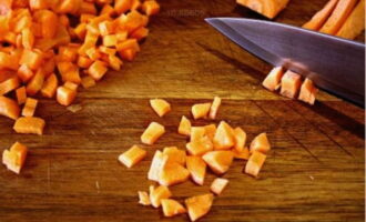 Снимаем кожуру с моркови и нарезаем овощ мелкими кубиками.