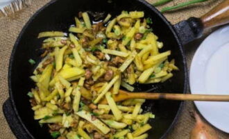 Когда картофель будет почти готов, добавьте к нему грибы с луком, посолите, приправьте по вкусу и жарьте еще 5-10 минут. Подавайте блюдо на стол горячим со сметаной и зеленью.
