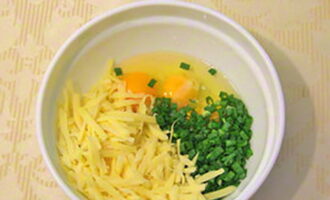 Зелень помойте и нарежьте. Смешайте в миске яйца, одну часть сыра и зелень. Добавьте 200 миллилитров сметаны, соль по вкусу и перемешайте.