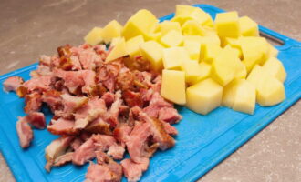 Картошку чистим и режем кубиками. Половину ребрышек достаем из кастрюли, снимаем с косточек мясо и измельчаем его.