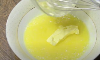 Добавляем в яично-сахарную массу размягченное сливочное масло и хорошо размешиваем.
