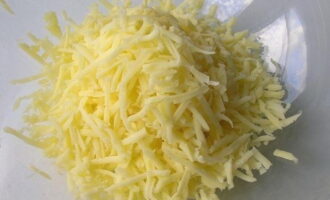 Кусочек твердого сыра натираем на терку с крупными зубчиками. Отправляем ингредиент в глубокую тарелку.