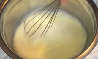 В отдельной миске взбиваем венчиком яйцо, оставшийся сахар, молоко и растопленное сливочное масло.