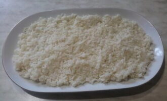 Отвариваем до готовности рис и выкладываем его ровным слоем на плоскую тарелку.