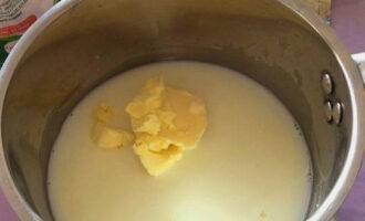 Наливаем в кастрюльку молоко. Нарезаем масло мелкими кусочками, добавляем его в кастрюльку.