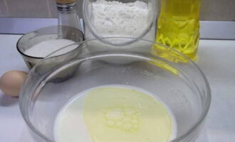 Как испечь тонкие блины на молоке с дырочками на кипятке? В глубокую тарелку вливаем молоко комнатной температуры, размешиваем в нем соль с сахаром и вливаем растительное масло.