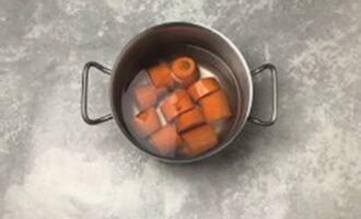 Как приготовить вкусные морковные котлеты? Морковь тщательно помойте, очистите от кожуры, разрежьте на несколько частей, переложите к кастрюлю и залейте водой.