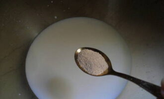 Пышные оладьи на молоке готовятся очень просто. Подогрейте молоко до 35-40 градусов. Добавьте сахар и сухие дрожжи, перемешайте.