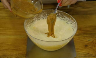 Начинаем постепенно взбивать мягкое масло миксером, к нему небольшими порциями добавляем молочно-желтковую массу. После соединяем смесь с ореховой пастой и взбиваем до получения однородности. 