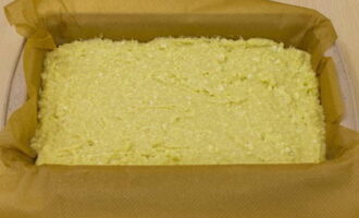 Форму застелите пекарской бумагой и смажьте сливочным маслом. Выложите в нее тесто.