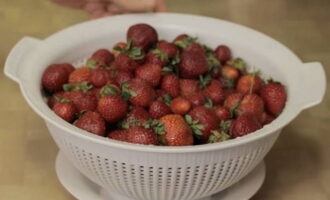 Начинайте с подготовки ягод. Переберите клубнику, удалите плохие плоды. Затем хорошо промойте и откиньте на дуршлаг.