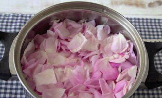 Как сварить варенье из лепестков розы в домашних условиях? Аккуратно, стараясь не сминать, оборвите лепестки с роз. Промойте их проточной водой и промокните бумажными салфетками. ¼ часть лепестков переложите в кастрюлю.