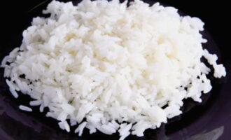 Подготовьте рис. Промойте его несколько раз. В результате вода должна стать прозрачной. Просушите рис с помощью бумажных полотенец. Положите рис в кастрюлю и залейте водой. Отправьте его на плиту и варите до готовности. Рис должен стать мягким. Промойте его ещё раз и переложите в небольшую тарелку. 