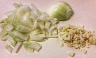 В это время займемся подготовкой овощей. Достаточно мелко нарезаем очищенную луковицу с чесноком.
