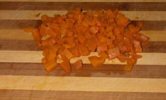 К свинине добавляем морковь, заранее нарезанную на крупные куски, лук и стебли зелени. Варим бульон на протяжении 30 минут на маленьком огне. После приготовления вынимание корешки из кастрюли, а мясо нарезаем на небольшие кубики. 